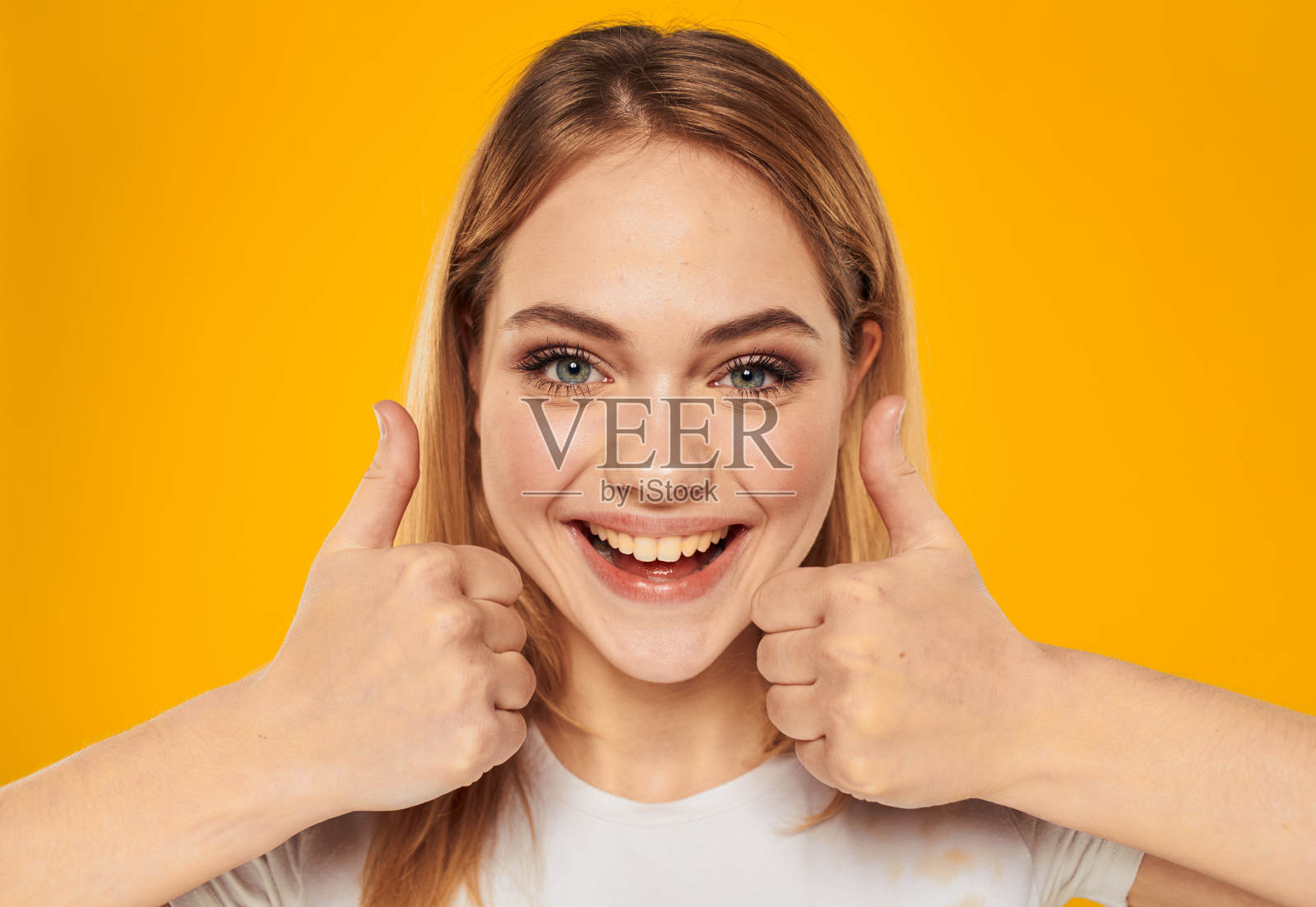 美丽的金发女子微笑着，表现出积极的姿态照片摄影图片