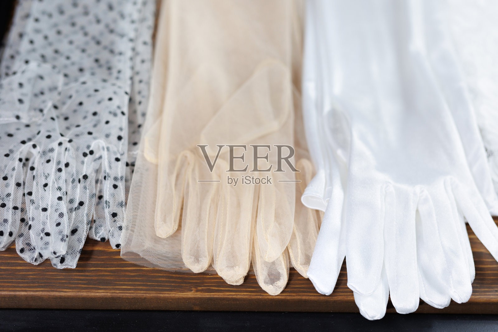 婚礼沙龙里为新娘挑选的大量薄面纱手套的特写。照片摄影图片