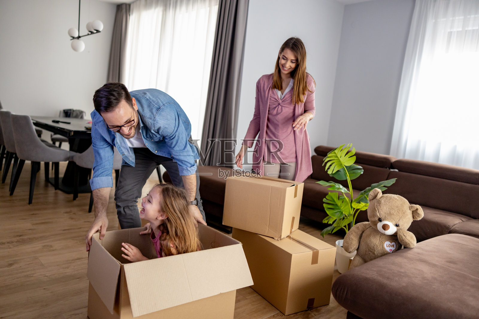 年轻微笑的幸福家庭在搬家时拆包照片摄影图片