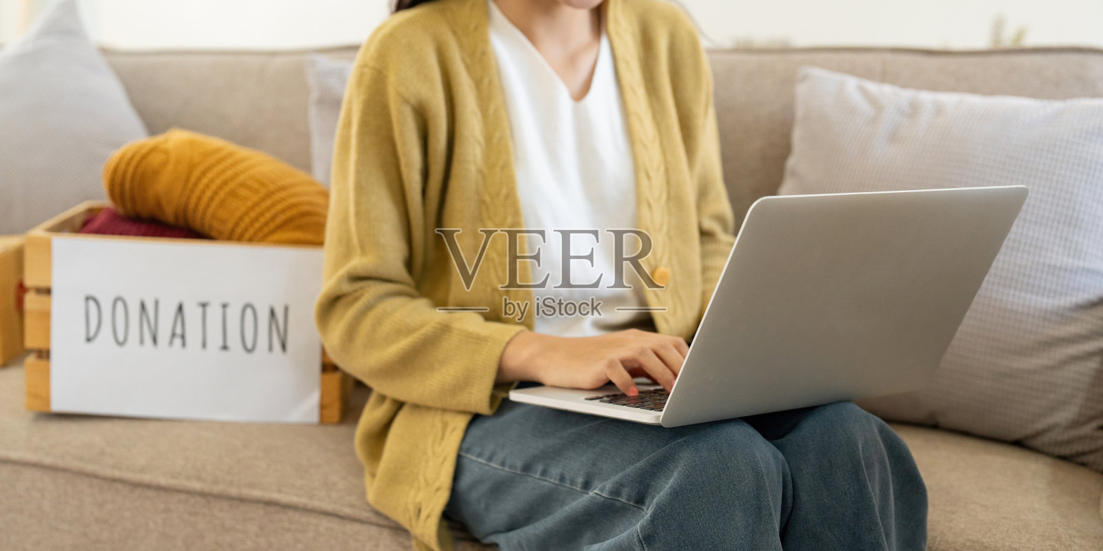 捐赠，亚洲年轻女子坐在家里的包对象，把东西放入捐赠箱与二手衣服，慈善帮助和有需要的人。回收,再利用照片摄影图片