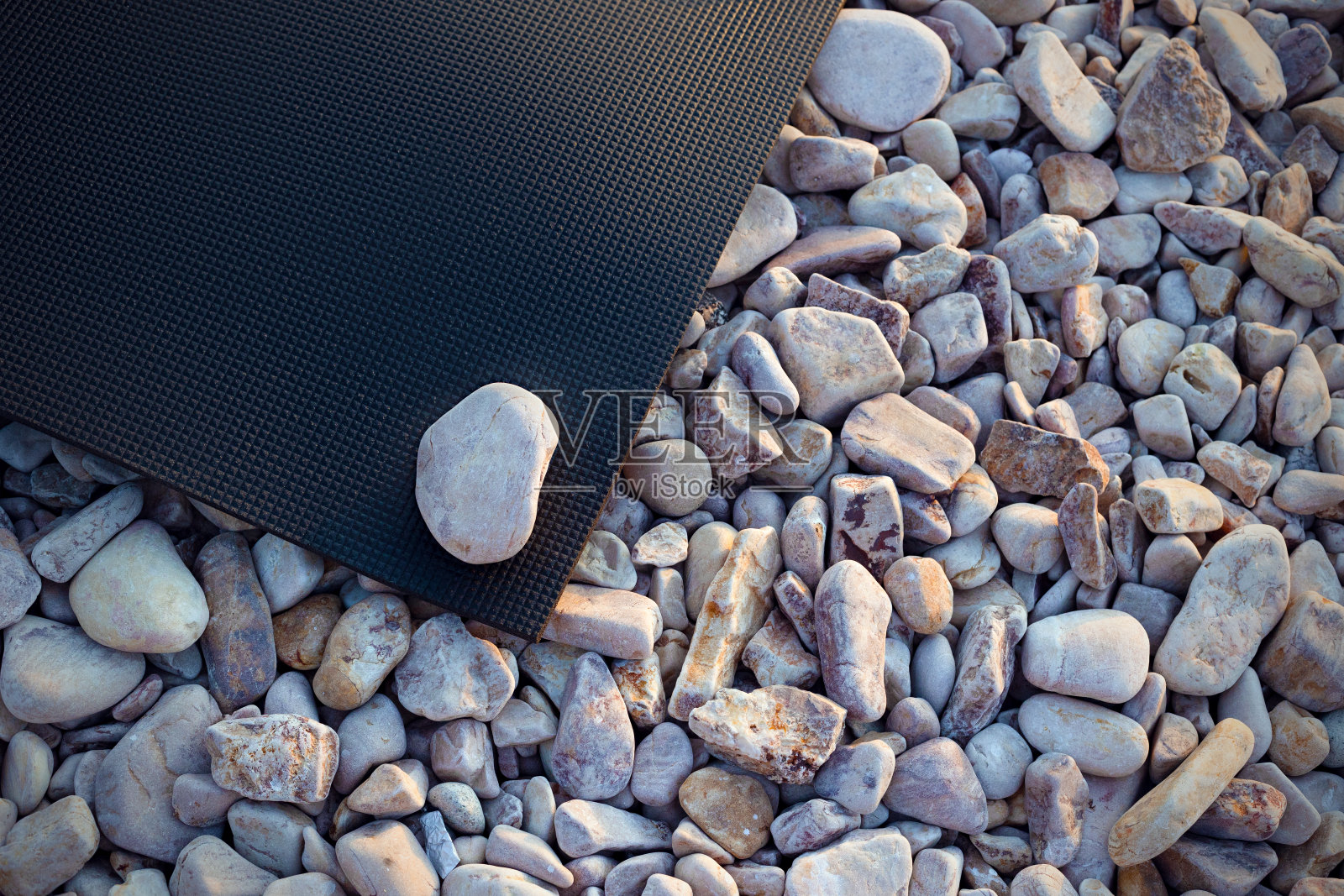 Нoga鹅卵石沙滩上的垫子照片摄影图片