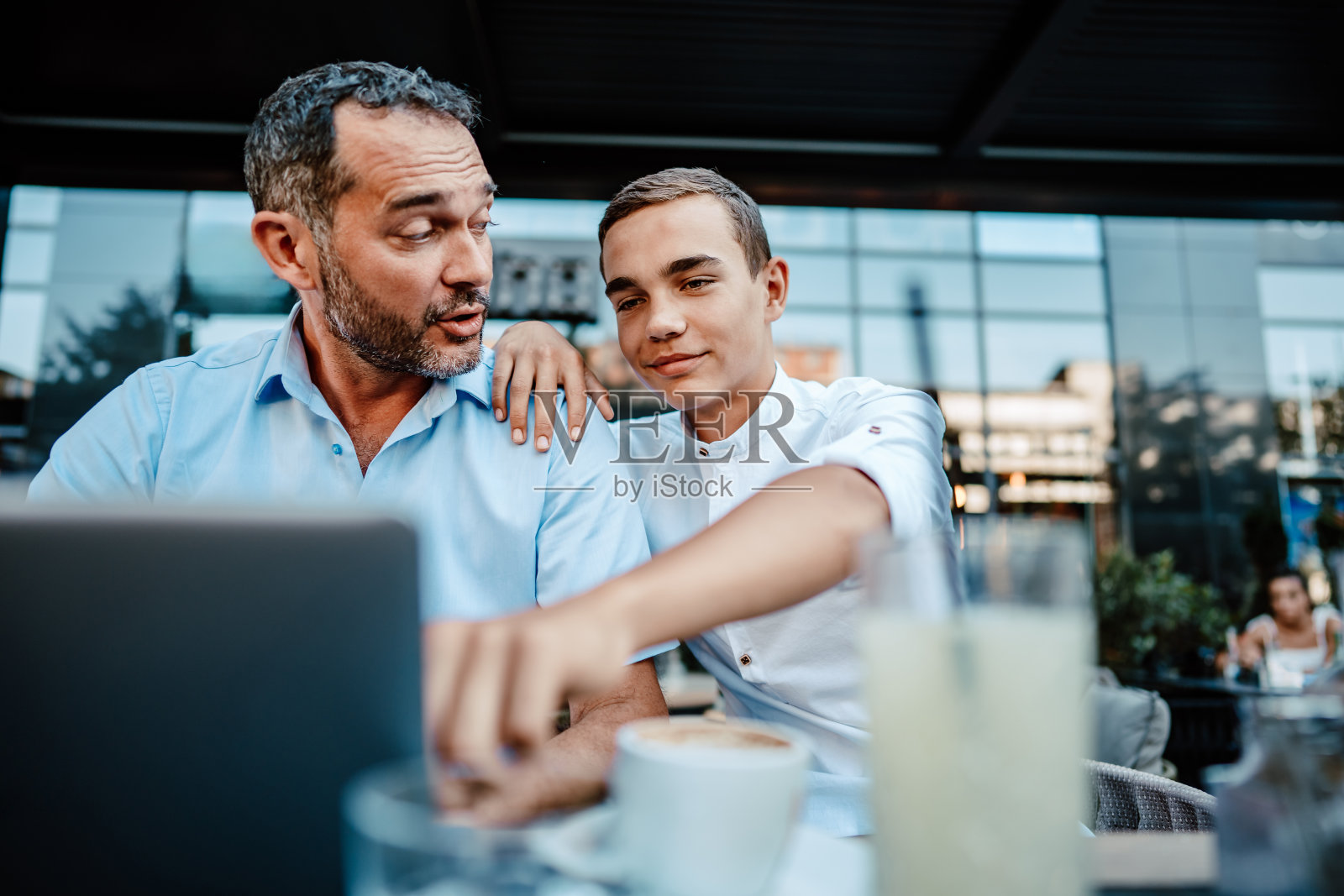 父子俩在现代咖啡吧或餐厅照片摄影图片