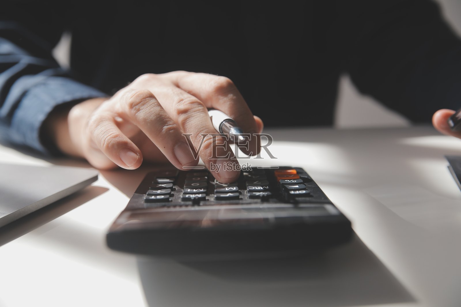 商人在办公桌旁用计算器计算数字，财务会计的概念照片摄影图片