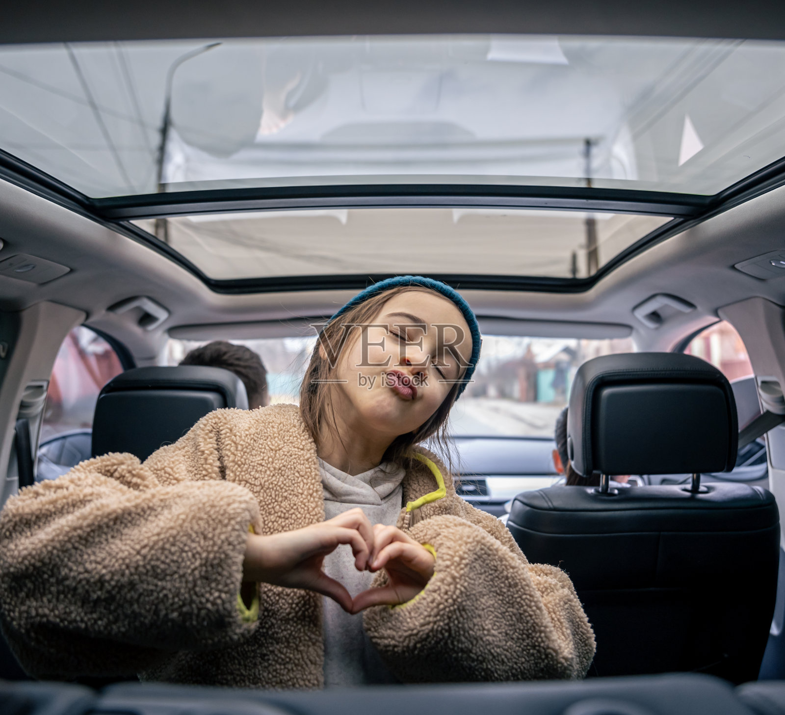 有趣的小女孩在汽车后座上摆姿势，在车里玩耍。照片摄影图片