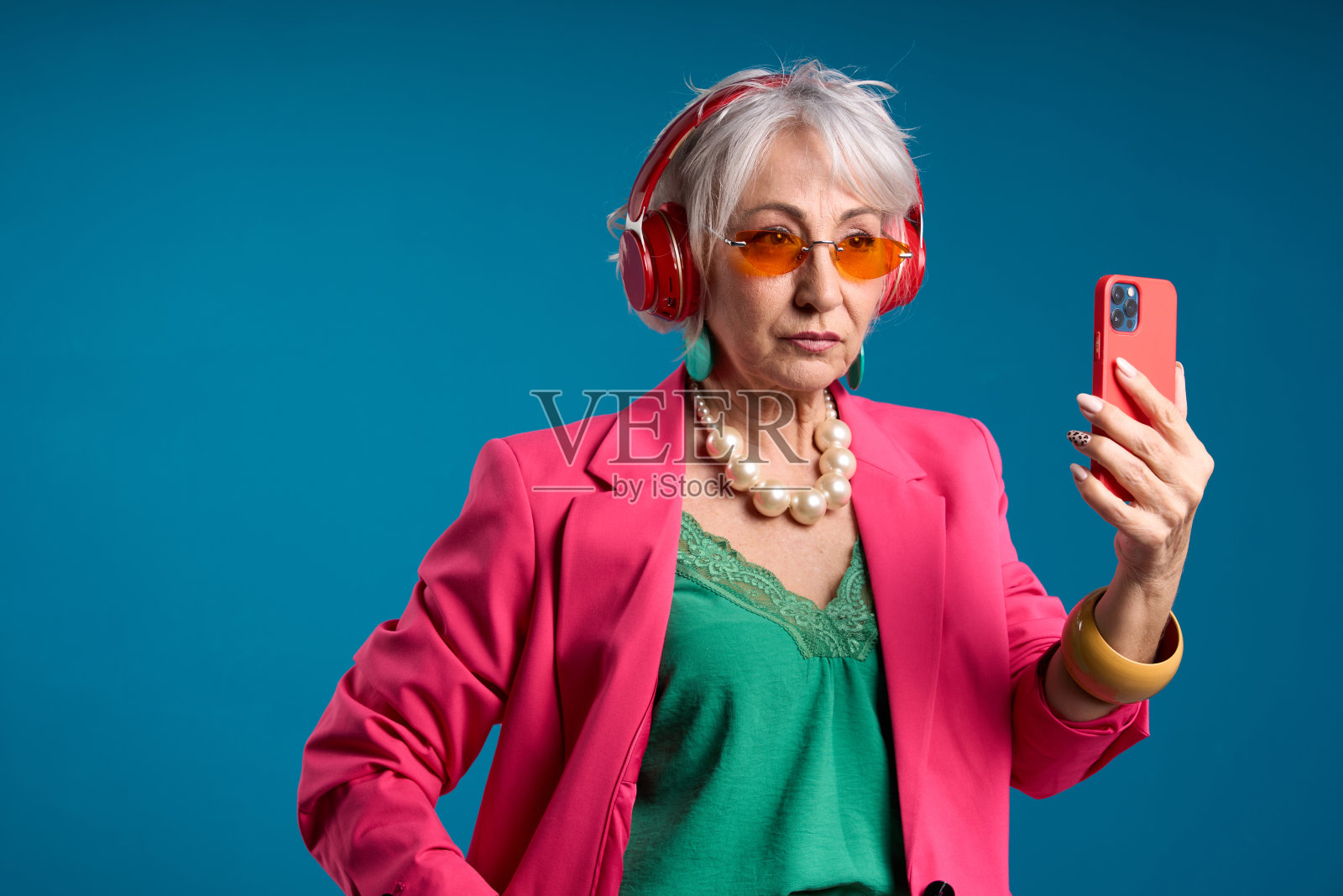 带着智能手机和耳机的时尚老年女性照片摄影图片