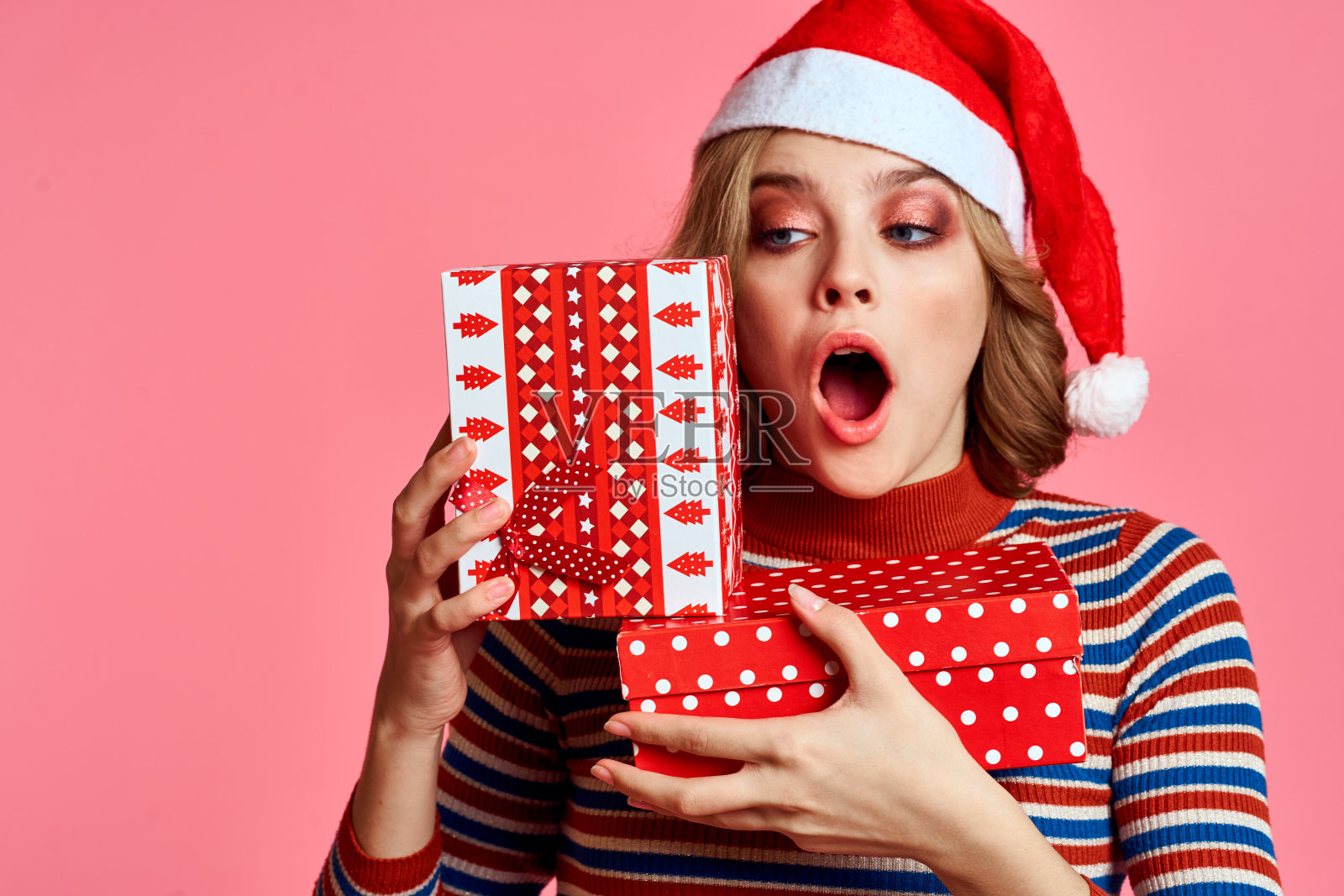 快乐女人用圣诞礼物盒装新年圣诞老人模型照片摄影图片