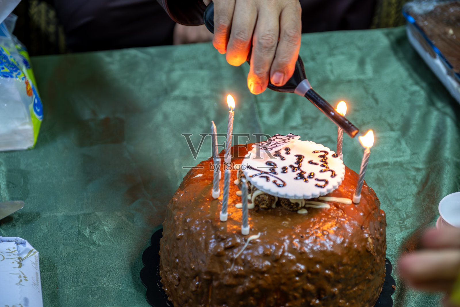 一只手点燃蛋糕上的生日蜡烛庆祝照片摄影图片