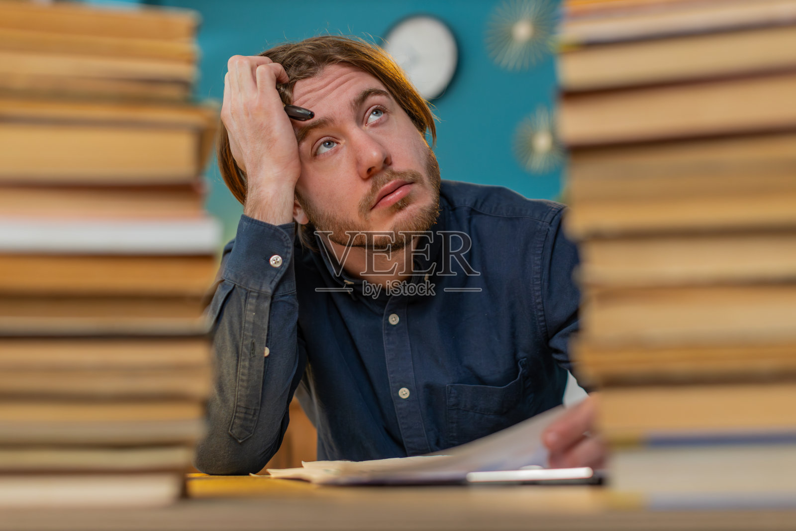 疲惫的商人移动成堆的书籍和审查文件报告在办公室努力工作照片摄影图片