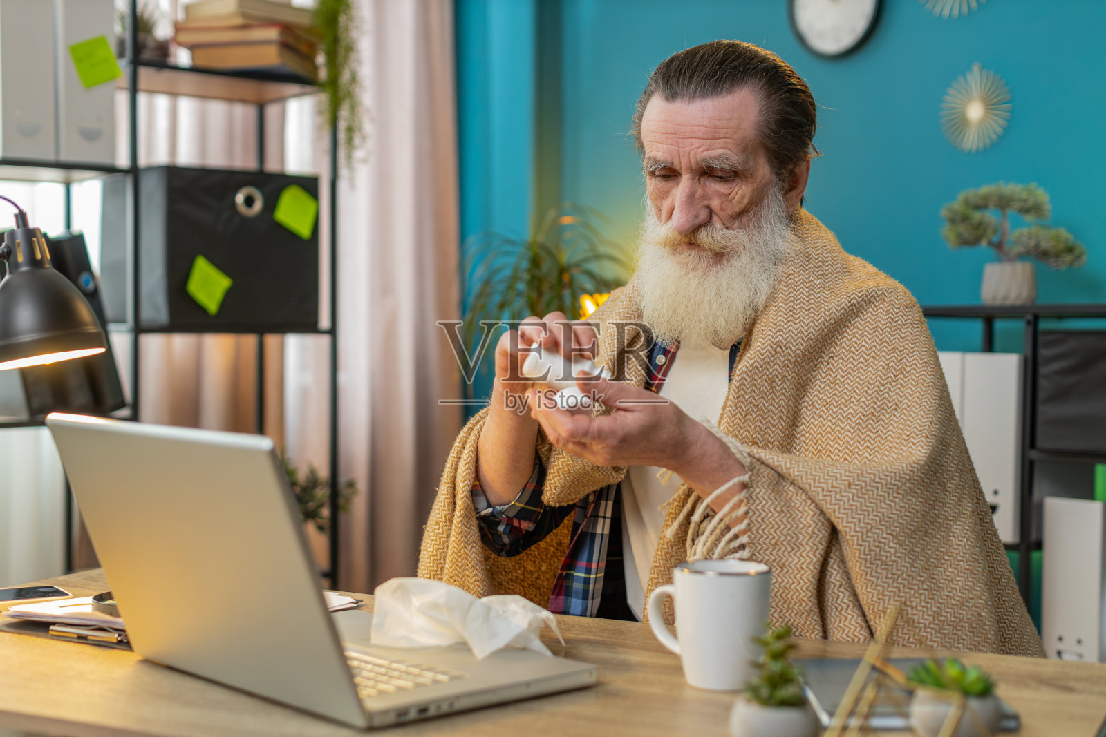 生病的老人患有感冒流感过敏吹打喷嚏擦鼻涕在家里用笔记本电脑工作照片摄影图片