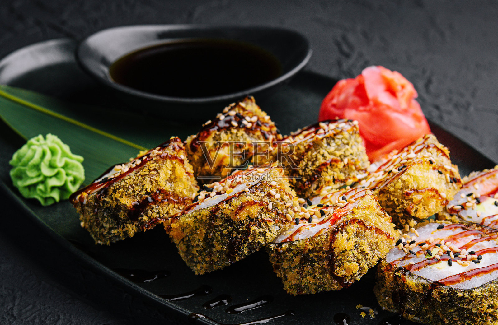 用黑石盘子盛上温热的生姜和芥末寿司照片摄影图片