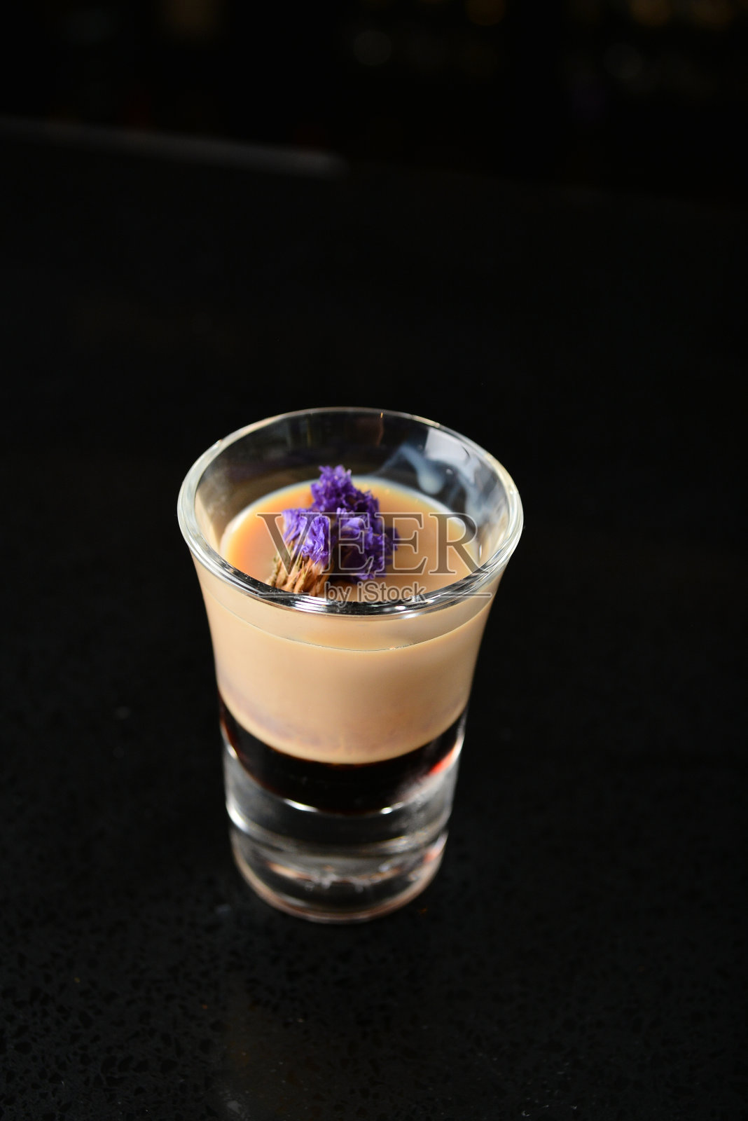 调酒师特别冷花生杏仁鸡尾酒/无酒精鸡尾酒与椰子奶昔和花高脚杯黑色背景豪华酒店酒吧餐厅冰饮料无酒精鸡尾酒菜单照片摄影图片