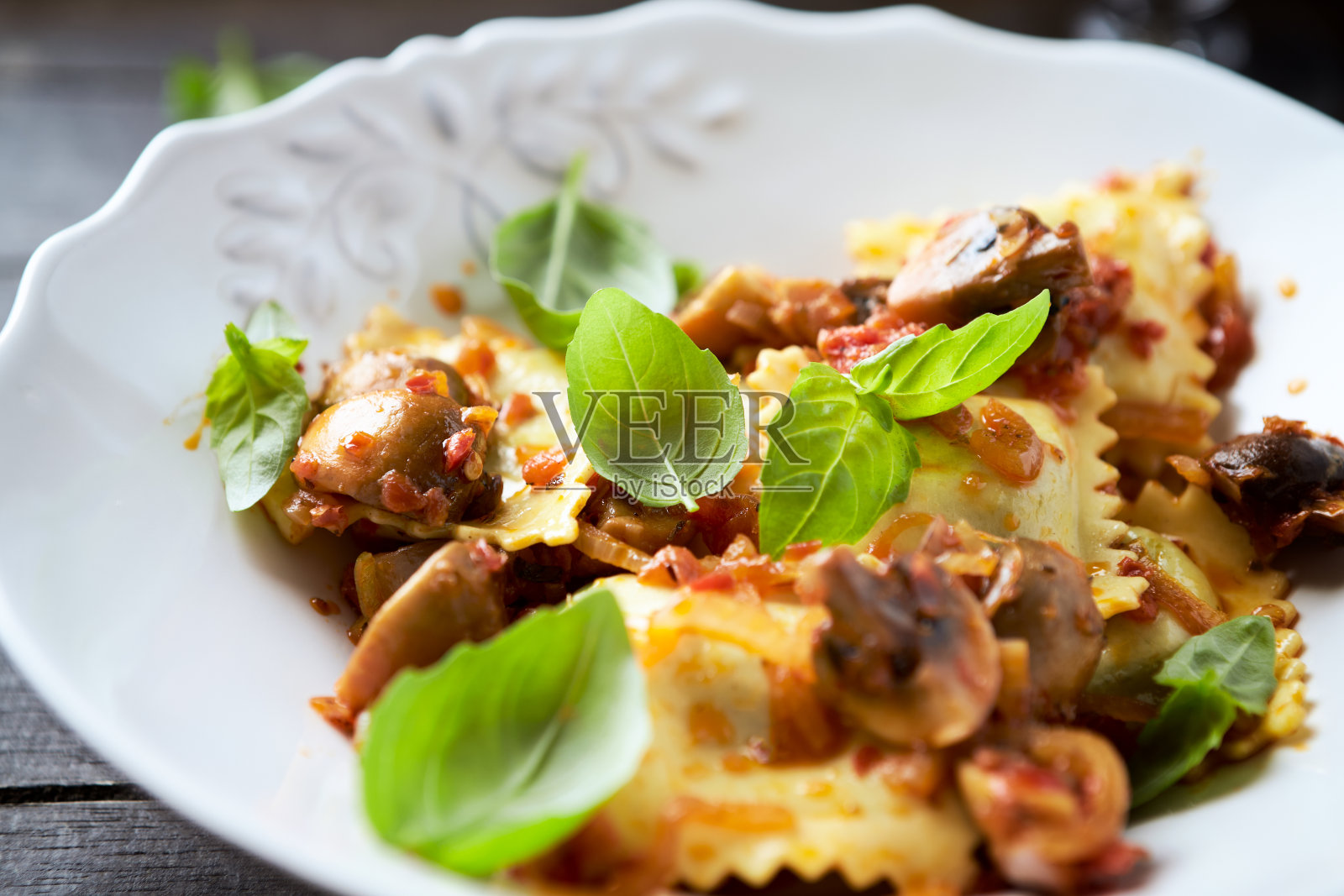 蘑菇和新鲜罗勒的意大利饺子。深色木制背景。近距离照片摄影图片