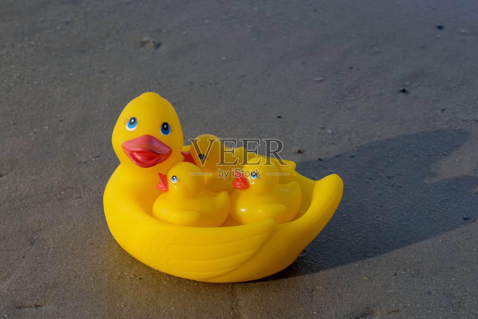 在沙地上的橡皮鸭照片摄影图片