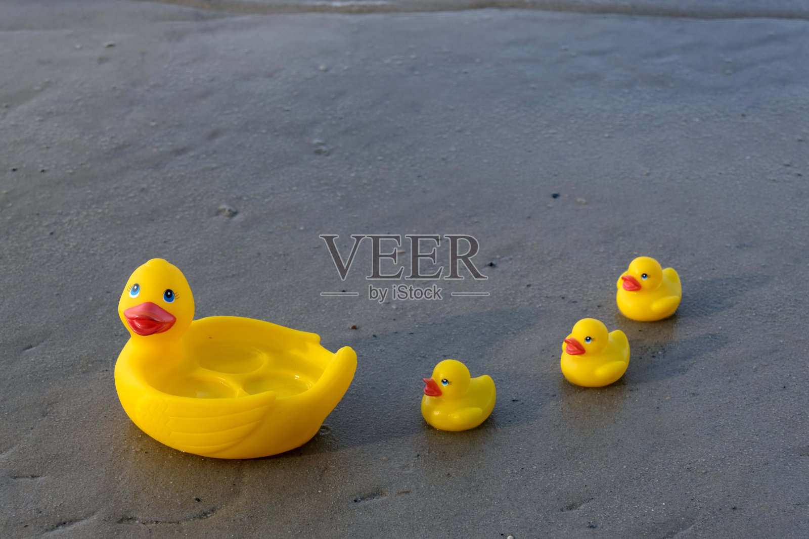 在沙地上的橡皮鸭照片摄影图片