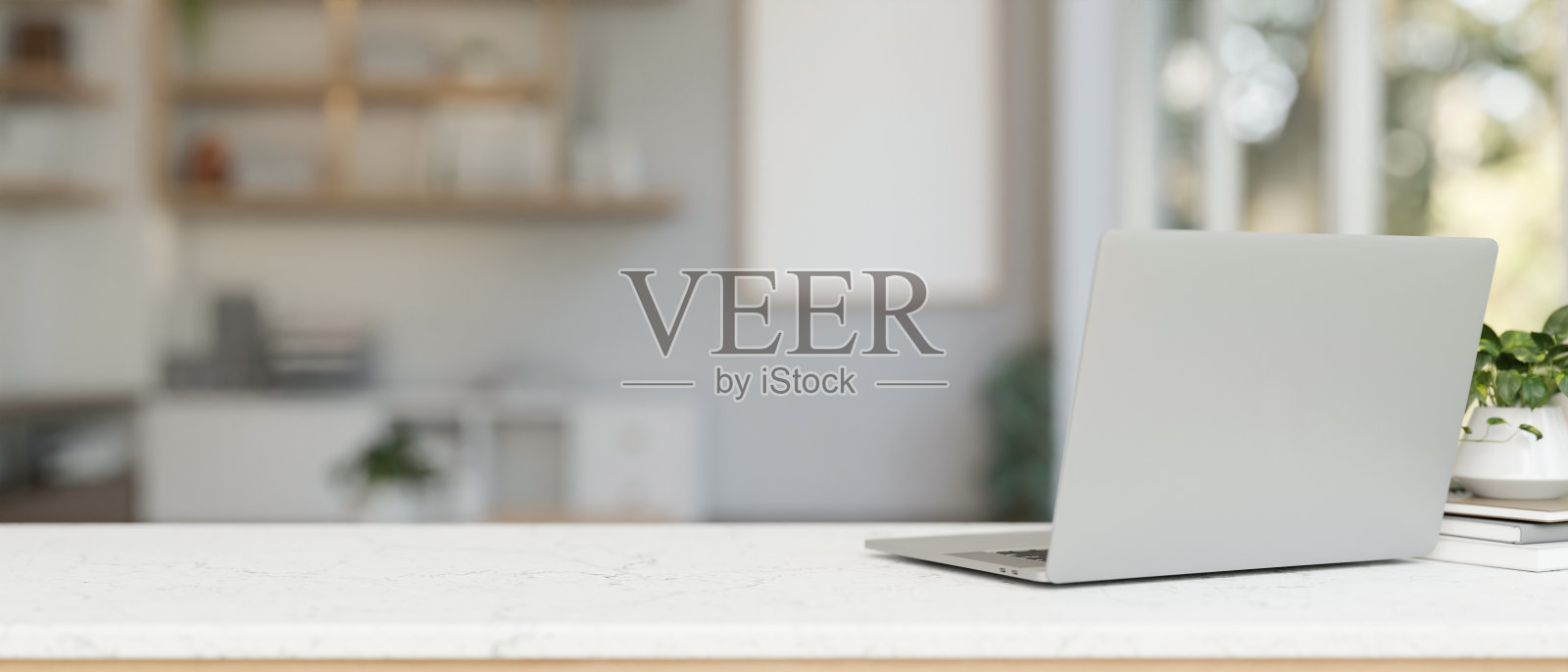 现代办公室白色桌面上的笔记本电脑的后视图。照片摄影图片