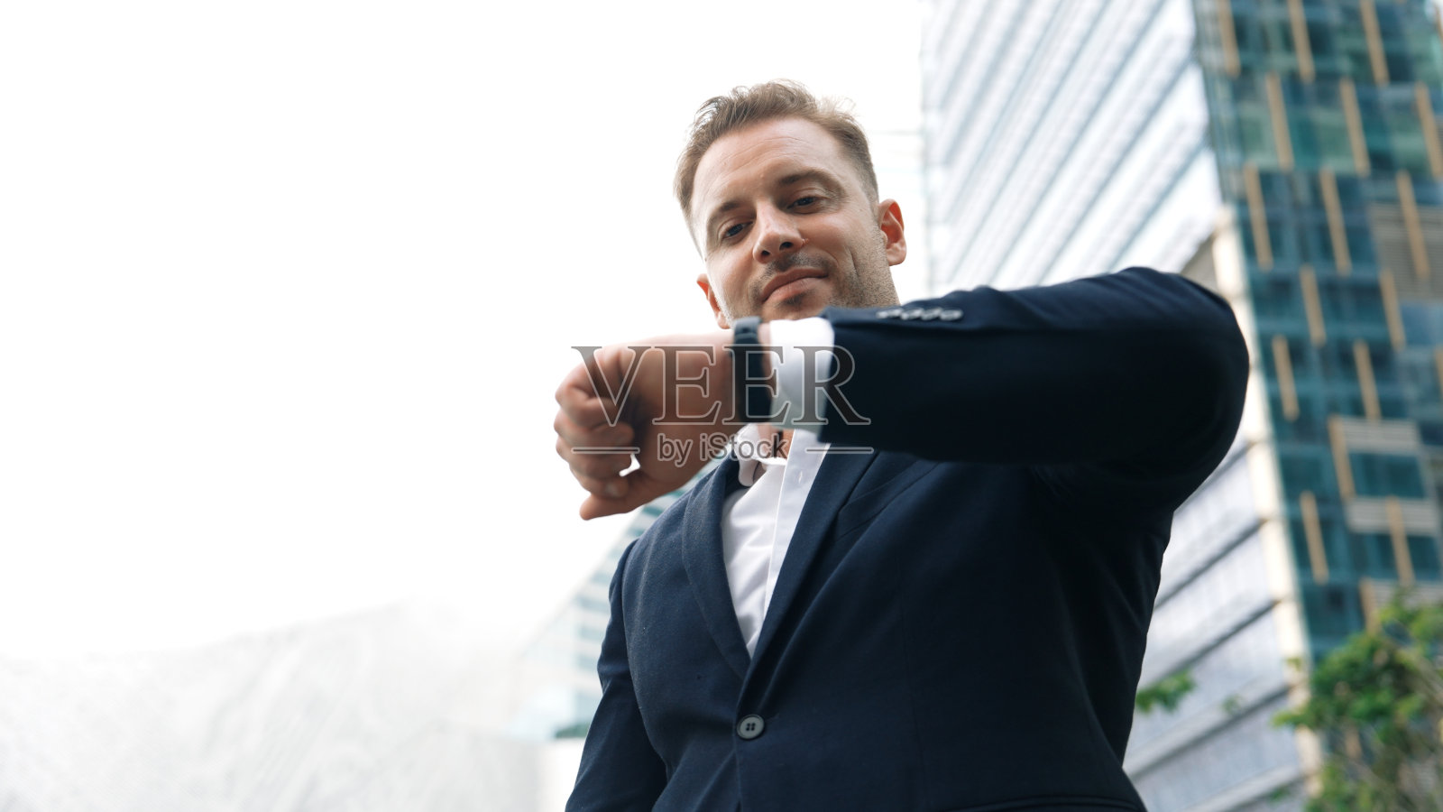 商人看手表的低角度相机提醒时间。彬彬有礼的。照片摄影图片