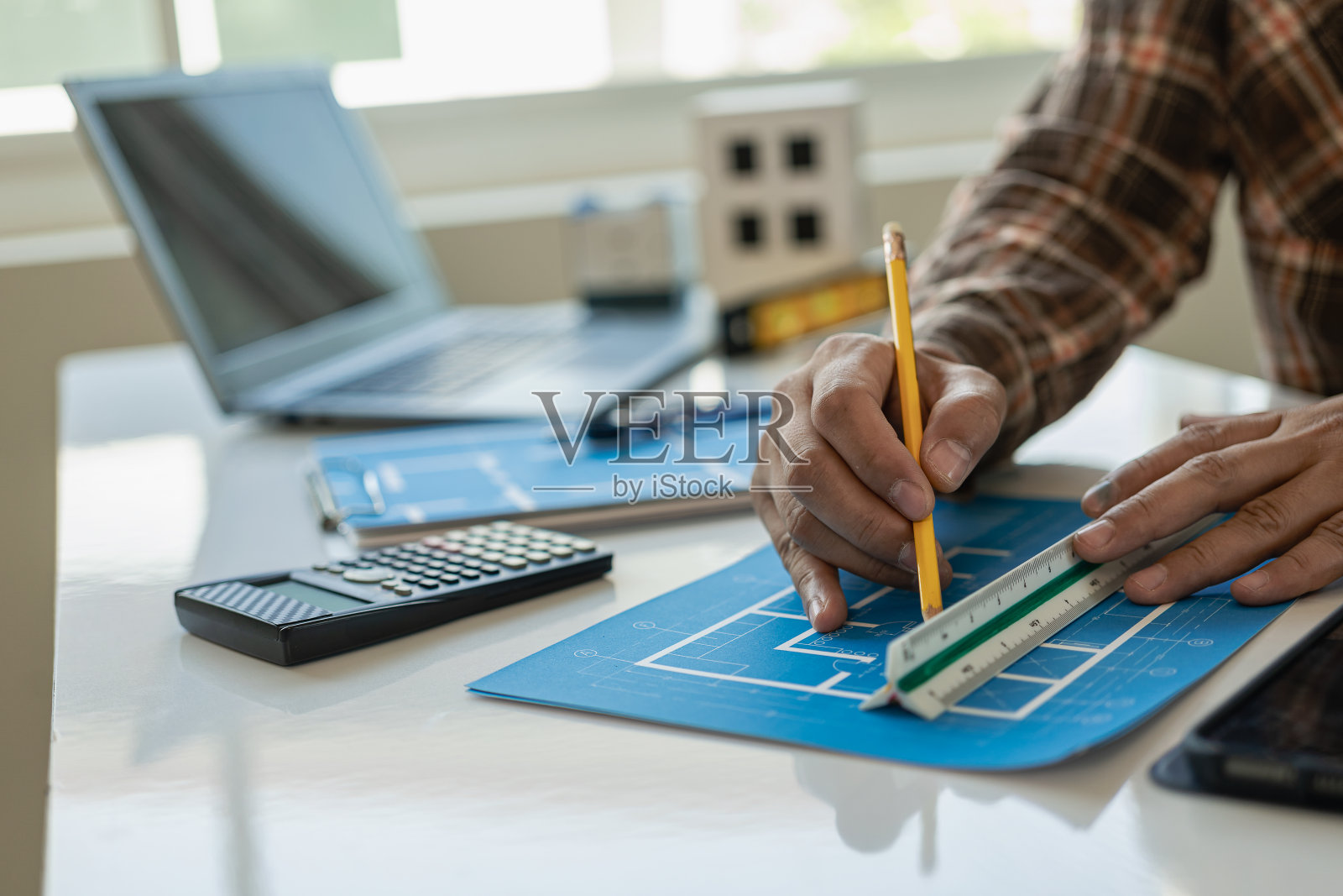 建筑师草拟蓝图，房屋建筑平面图，建筑工程师草拟设计。基础设施，纸桌和笔记本电脑与视觉建设，在家工作的概念，特写形象照片摄影图片