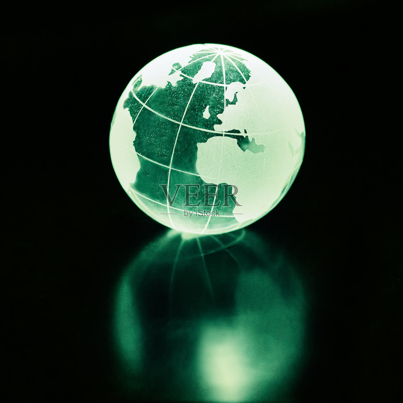 玻璃球放在桌子上。黑色背景的地球。可持续性。照片摄影图片