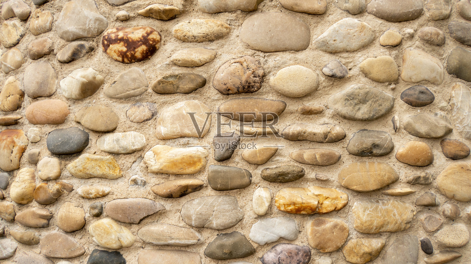 用不同大小的鹅卵石砌成的天然石墙照片摄影图片