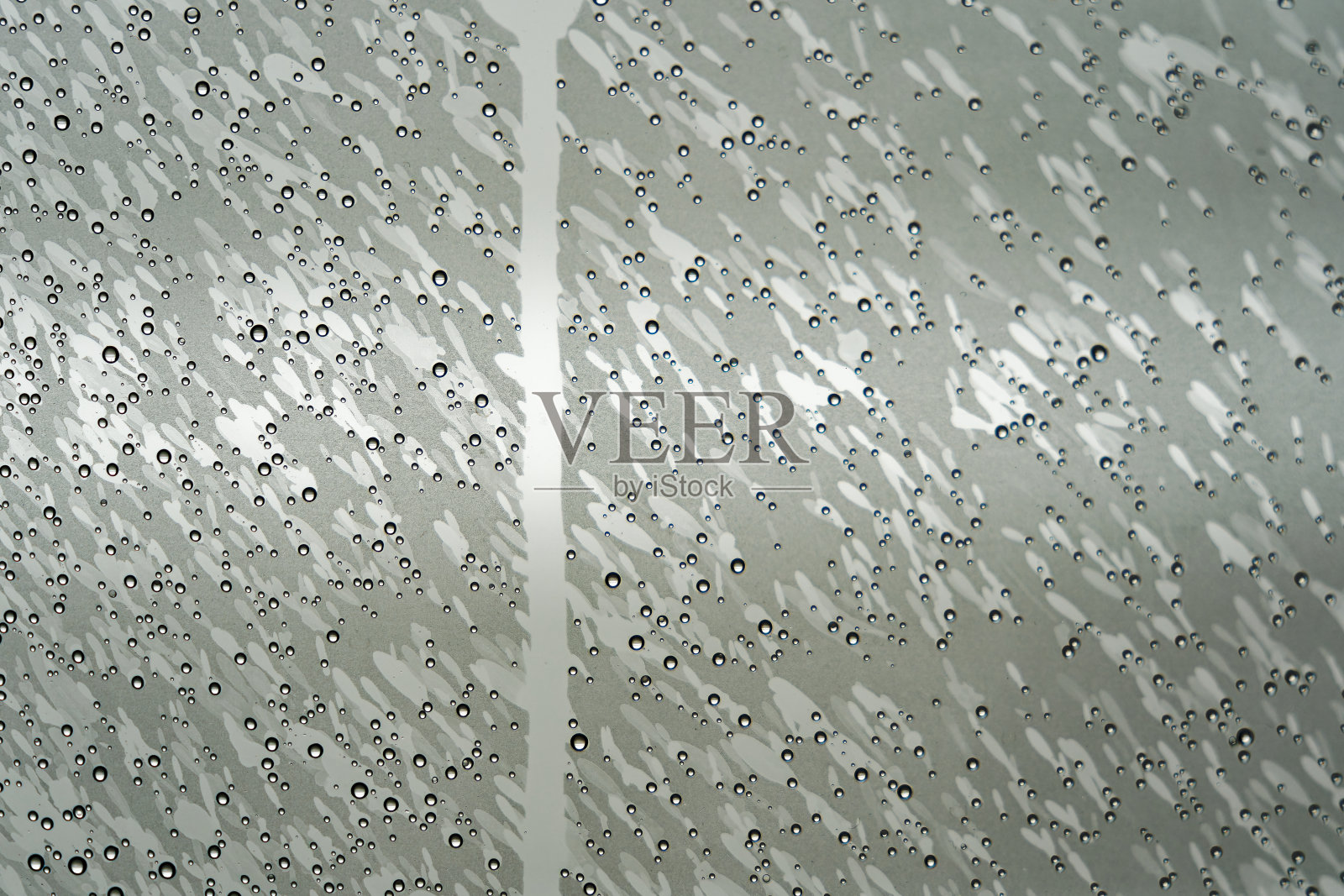 淋浴间玻璃门的抽象表面有水滴和凝结。照片摄影图片