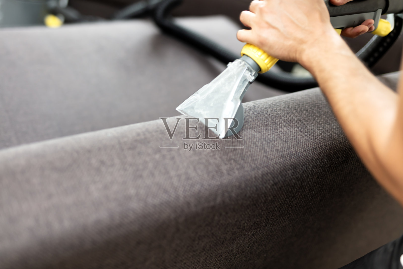 一个人在客厅用吸尘器吸沙发照片摄影图片