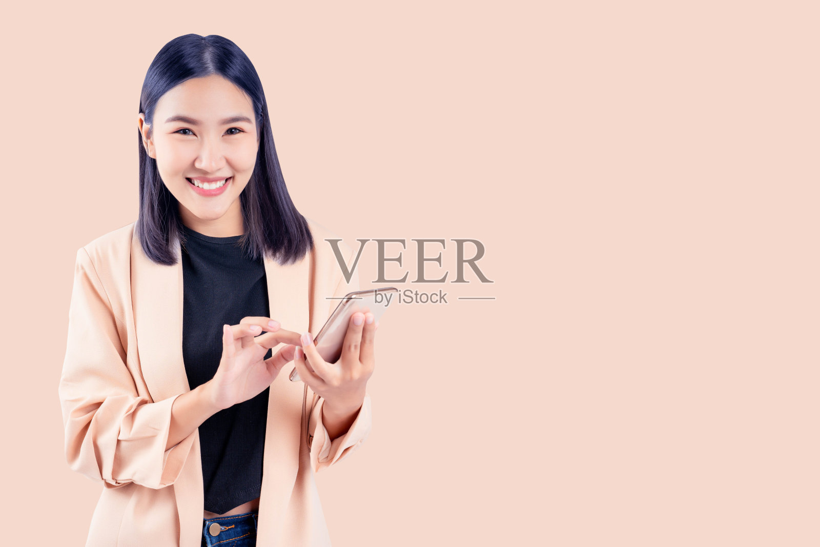 带着智能手机微笑的年轻女子照片摄影图片