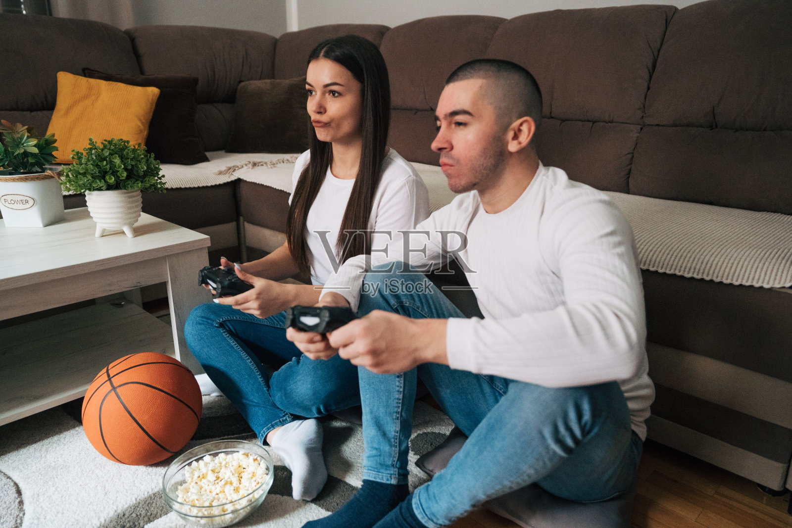 年轻夫妇在家里玩电子游戏。照片摄影图片