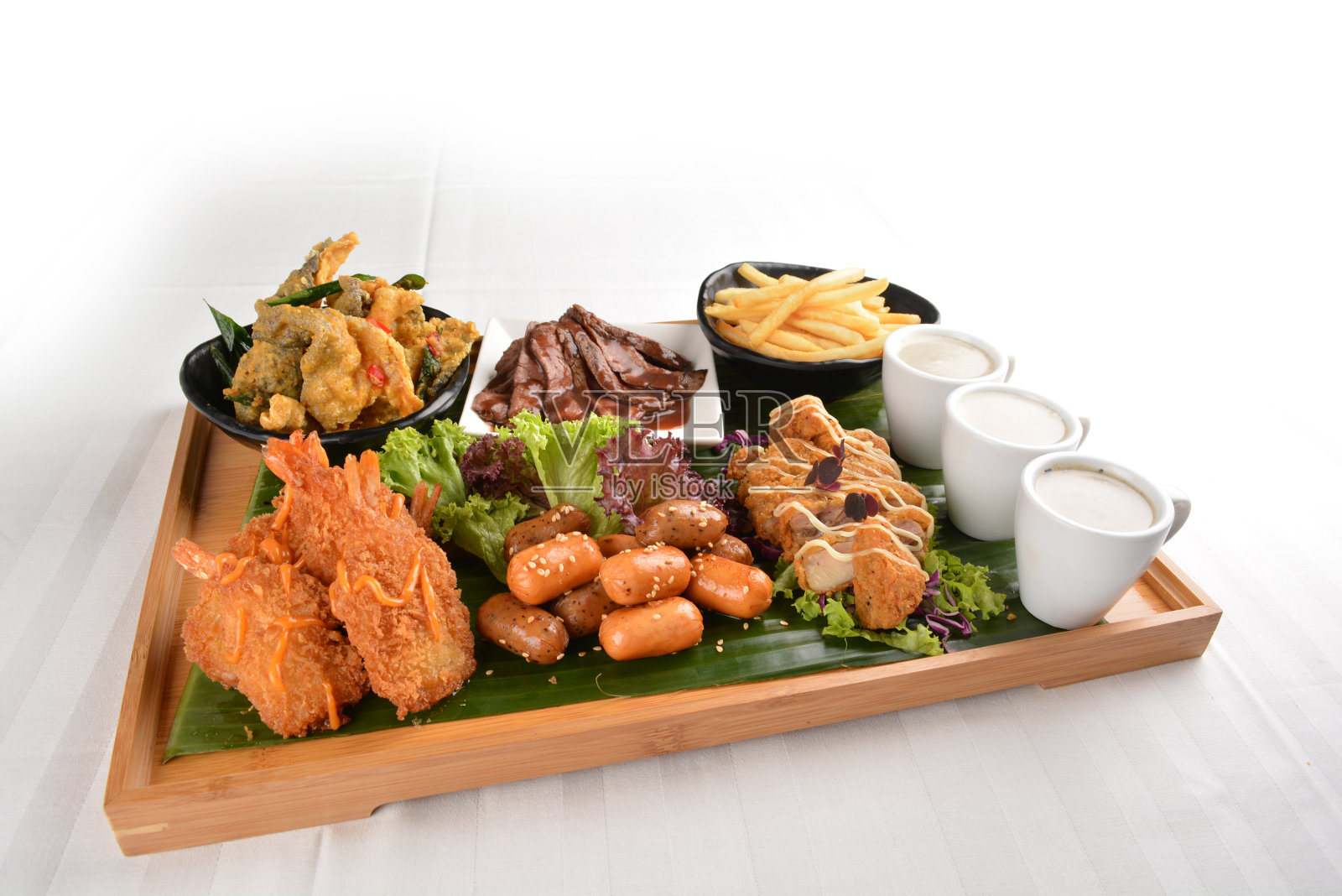 巨型开胃拼盘搭配迷你热狗、蘑菇汤、油炸天妇罗对虾、和牛片、咸蛋黄鱼皮、香蕉叶法式薯条木板派对托盘亚洲咖啡馆西式小吃餐厅清真开胃菜单照片摄影图片