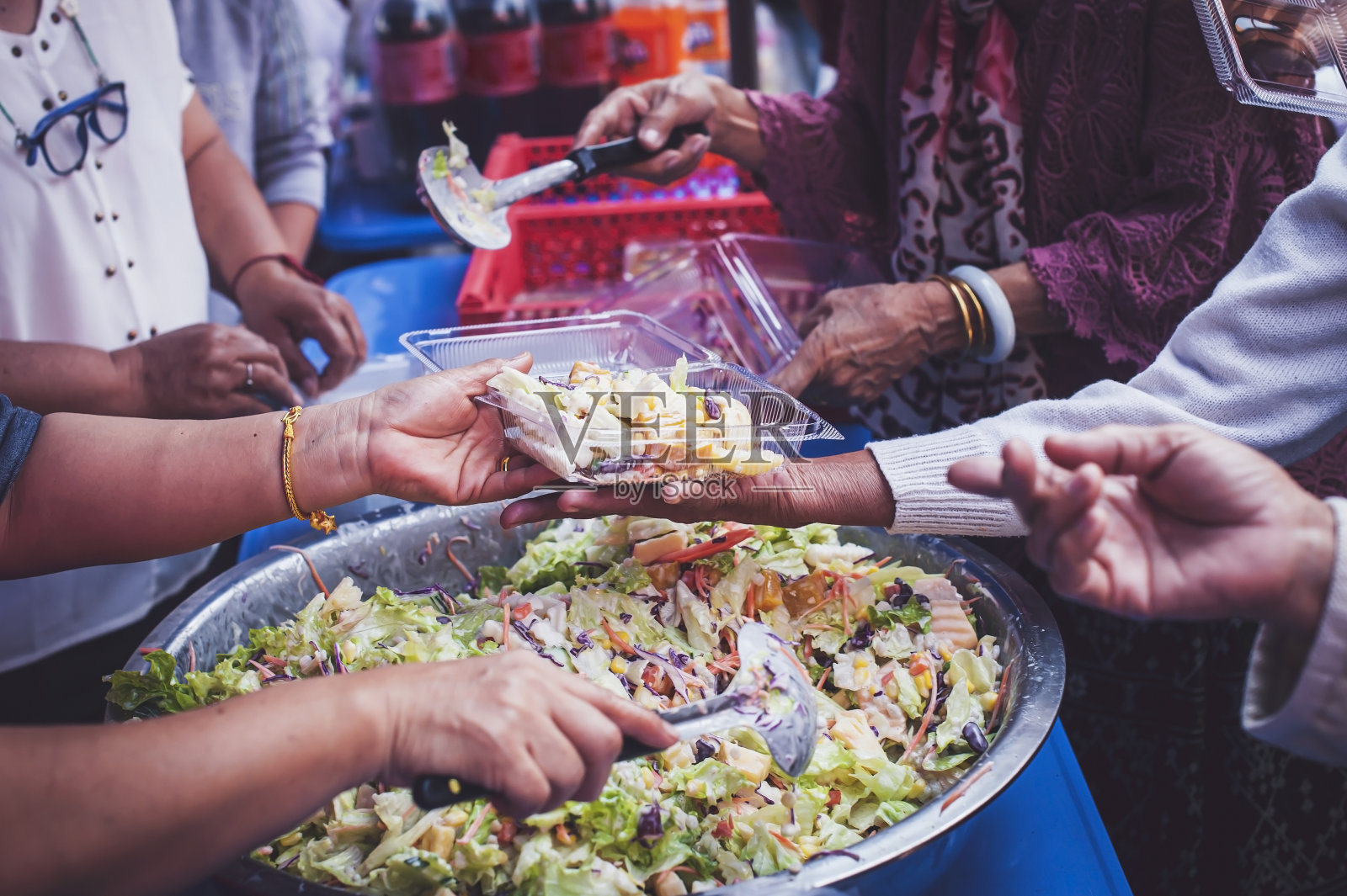 向饥饿的人分享食物的概念:志愿者正在向穷人分发食物。照片摄影图片