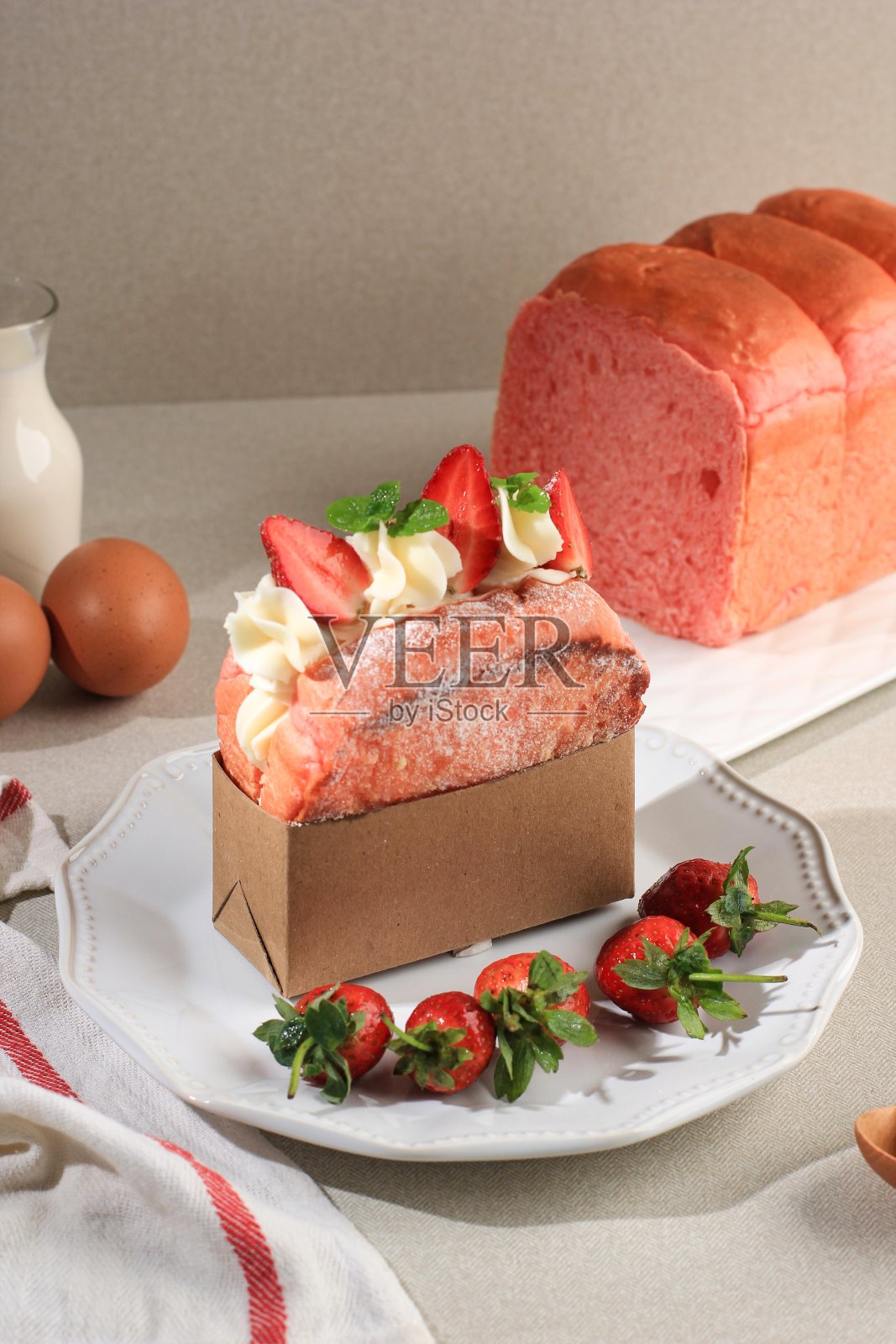 新鲜出炉的粉色面包三明治，奶油奶酪和草莓，奶油背景，干净的造型为广告照片摄影图片