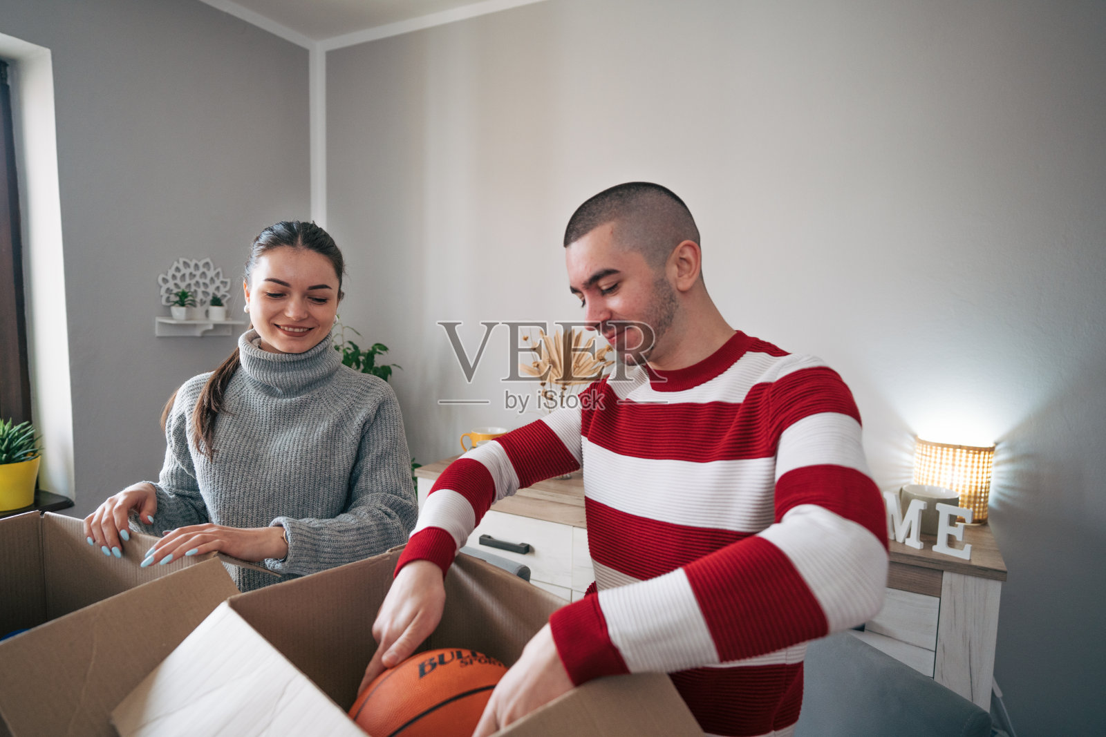 一对年轻夫妇正在为慈善机构收拾衣服照片摄影图片