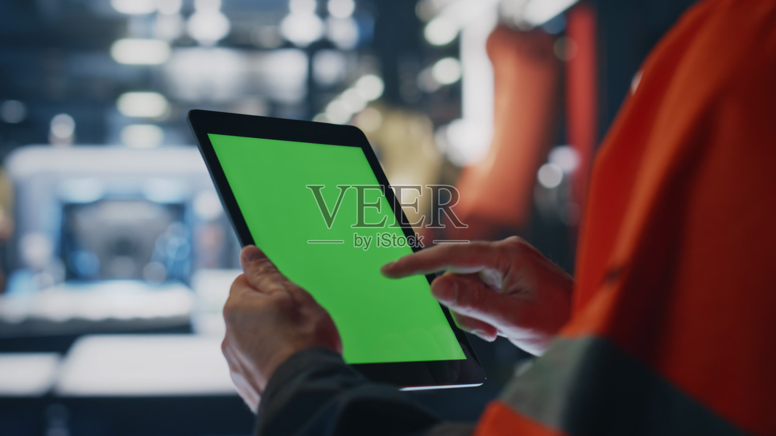 专家的手拿着绿屏平板电脑在制造工厂附近。照片摄影图片