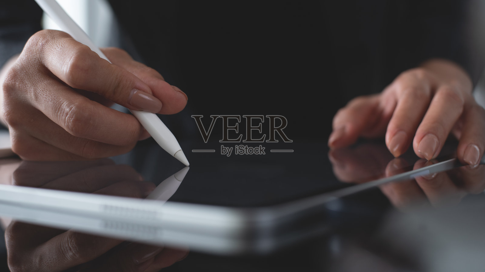 女商人用触控笔在办公桌上的数字平板电脑上签署合同的特写。商务女经理校对电子文件，电子签名，电子签名移动应用程序照片摄影图片