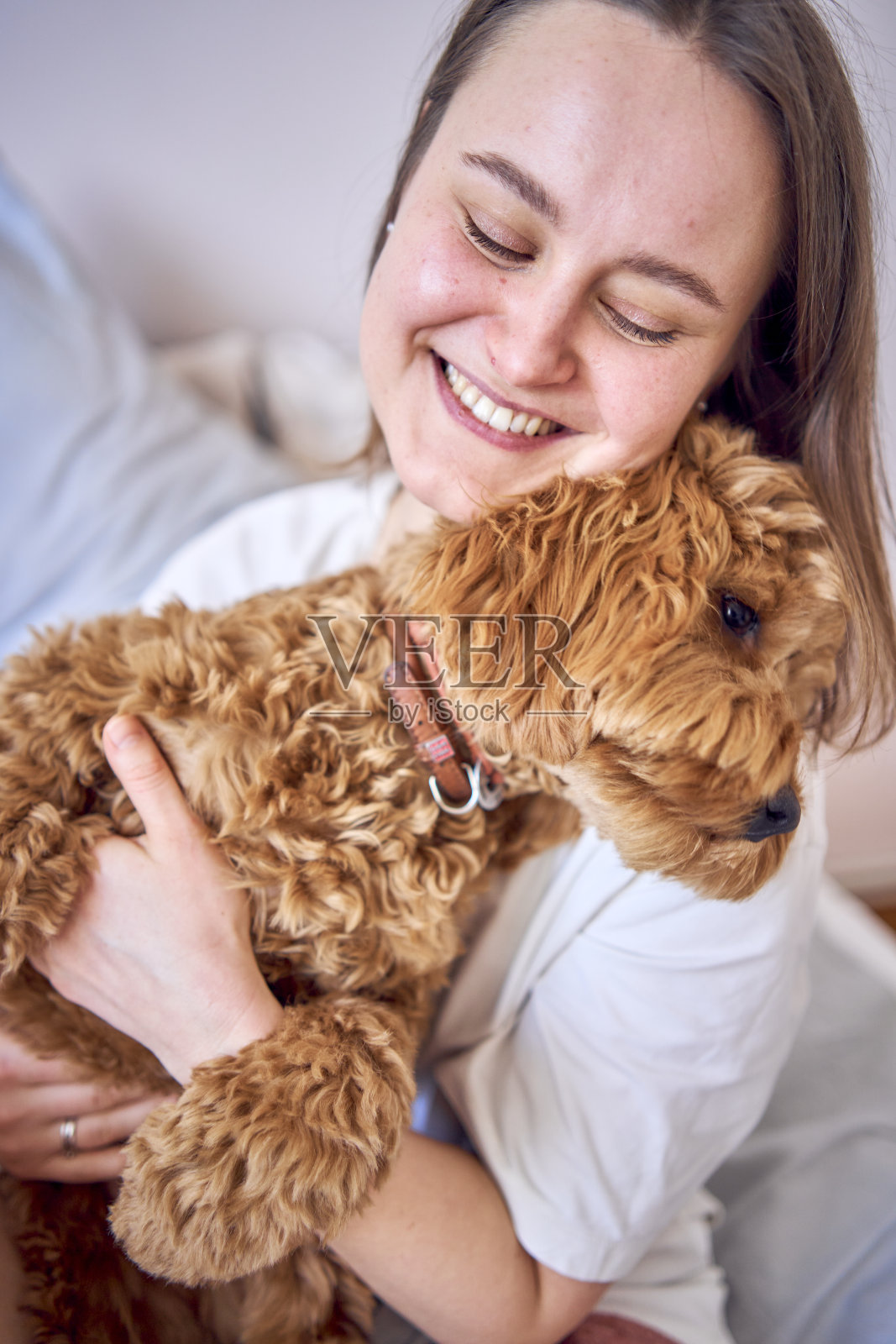 年轻女子在床上玩和亲吻公鸡女孩，极简主义照片摄影图片