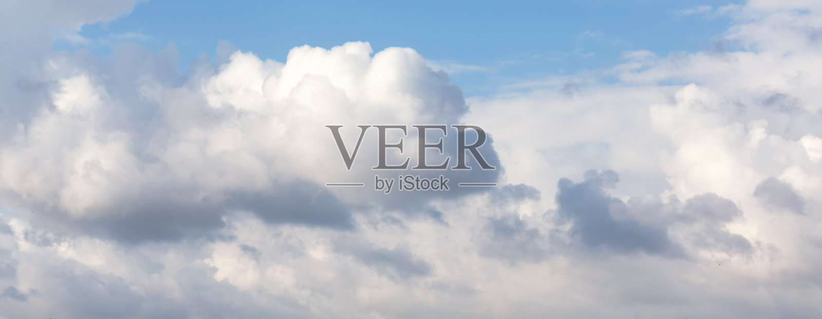滚滚的云漂浮在广阔的蓝天上，展示了天气的动态和轻盈的舞蹈。横幅。大气背景或壁纸照片摄影图片