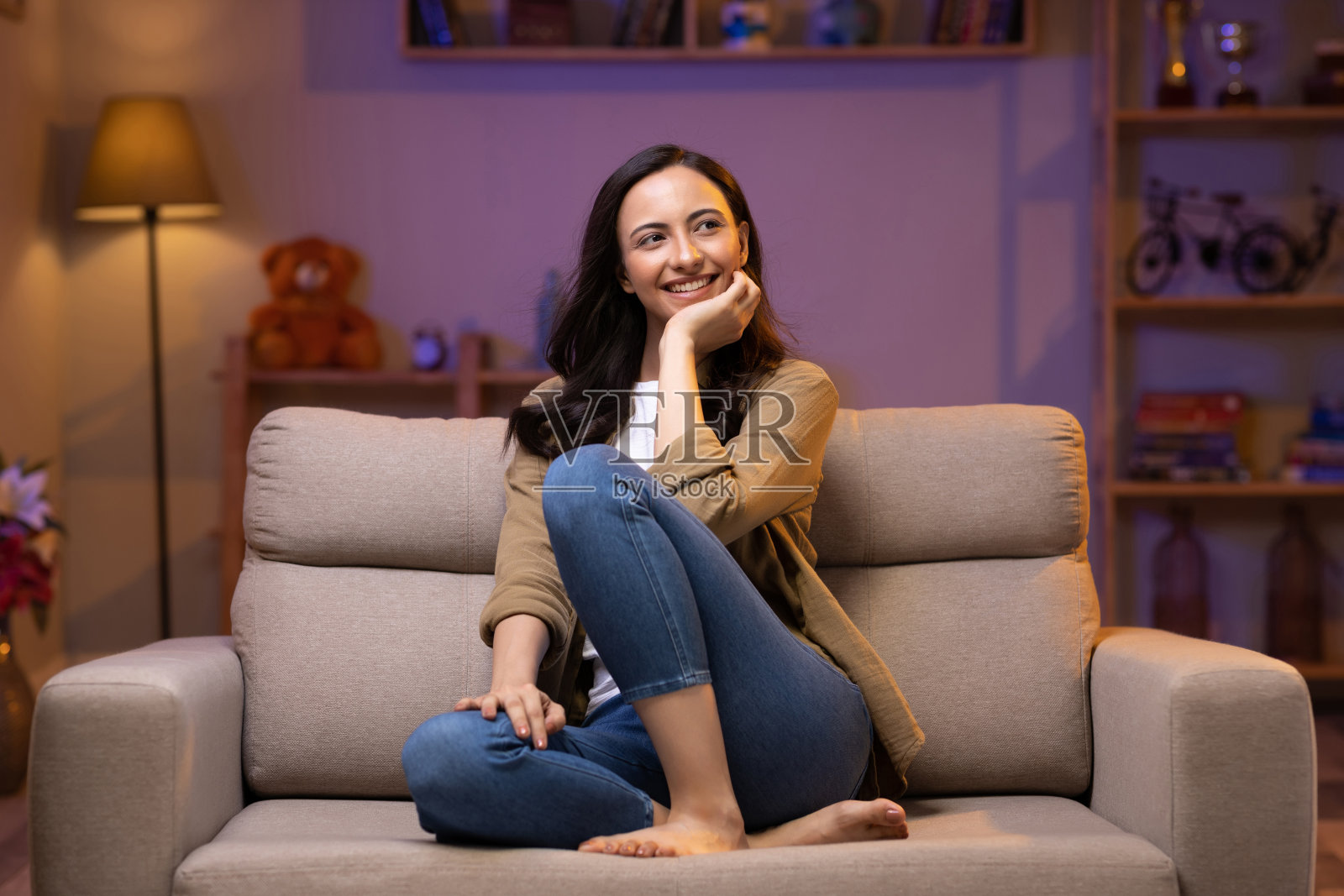 年轻女子坐在客厅舒适的沙发上放松照片摄影图片