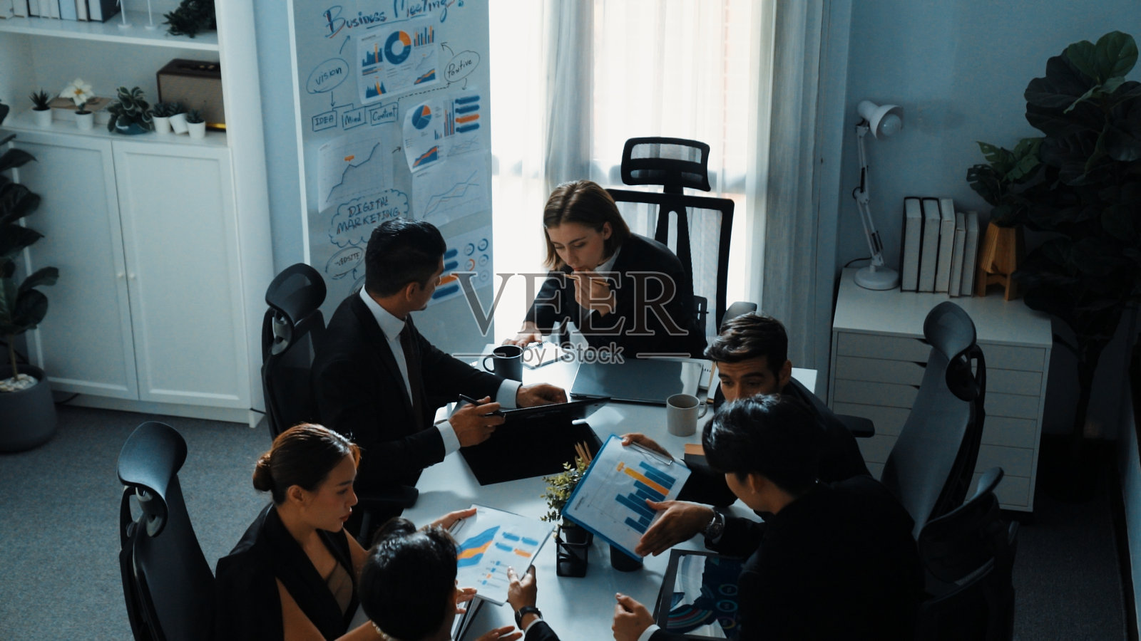 智能经理在平板电脑上查看财务统计数据的俯视图。理事会。照片摄影图片