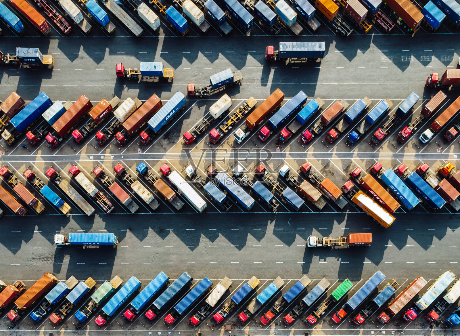 鸟瞰图，在港口行驶的一排排卡车和拖车照片摄影图片