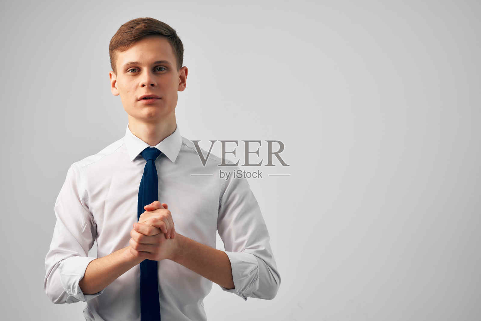 穿白衬衫系领带的男人用手做着成功的手势，充满自信照片摄影图片