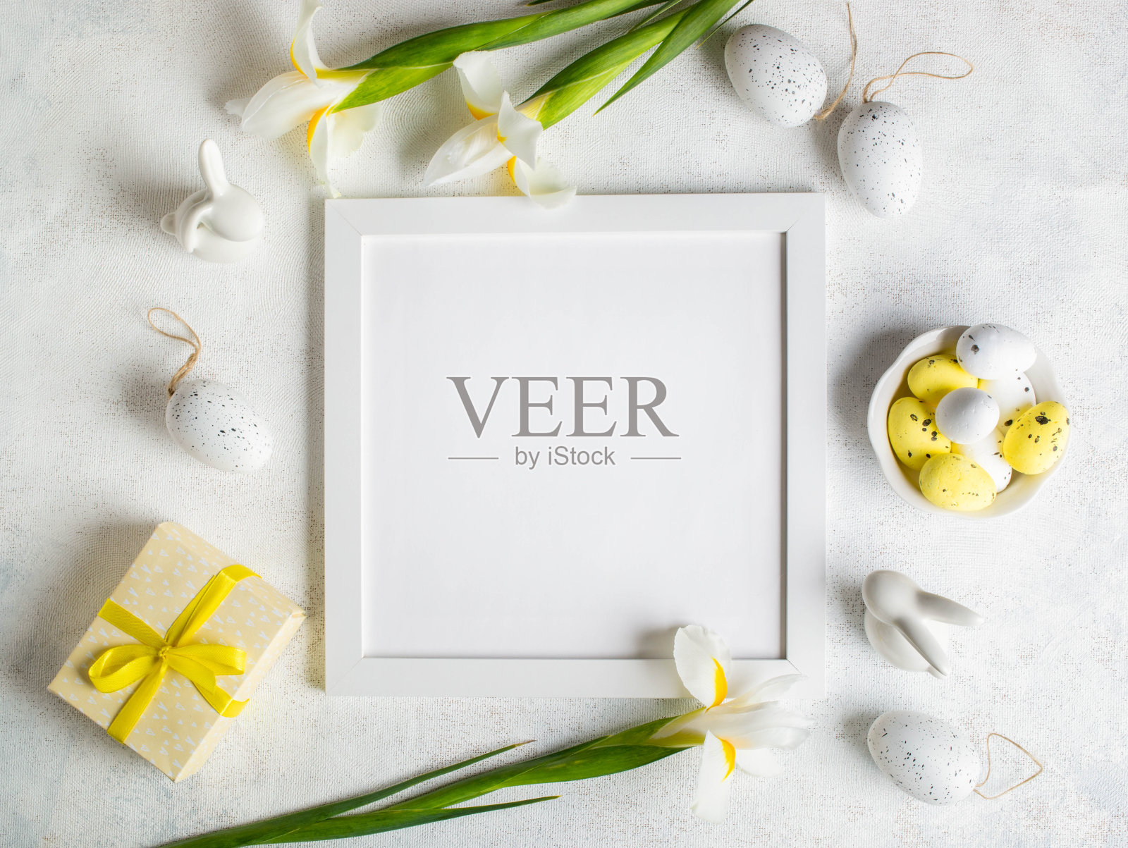 方形空白框，鸡蛋，鲜花，礼盒，小兔子上白。复活节模型。前视图。照片摄影图片