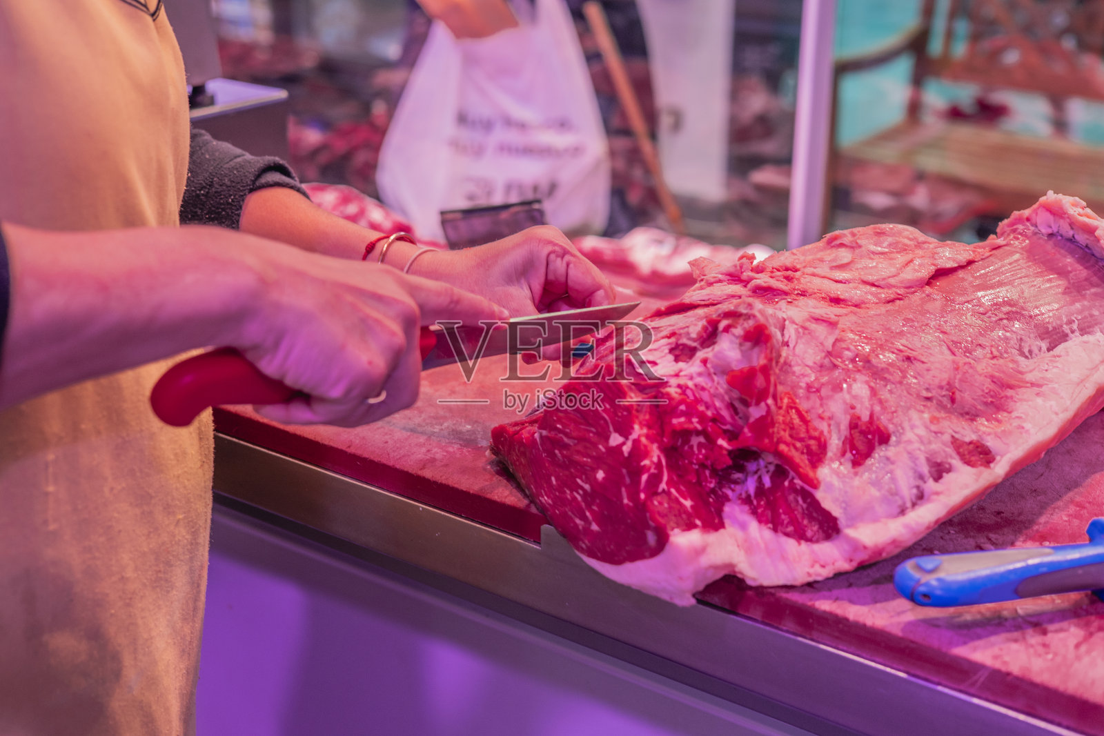 女屠夫用刀切牛排的特写照片摄影图片