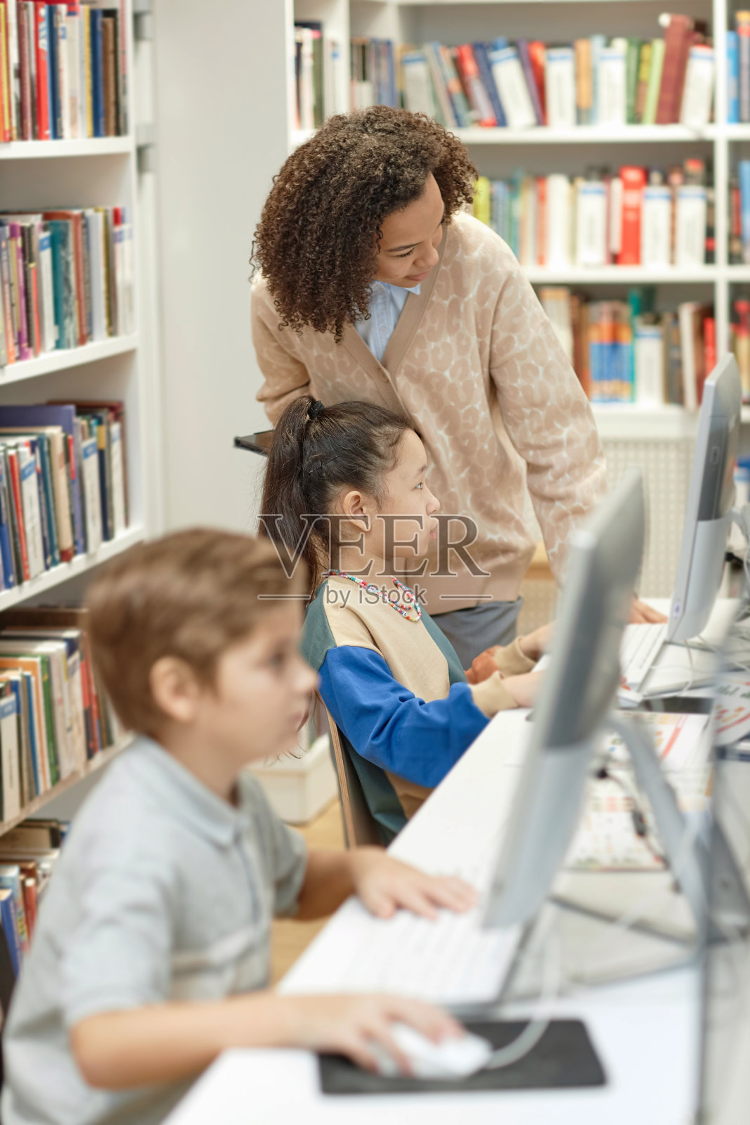 老师在It课上帮助孩子们使用电脑照片摄影图片