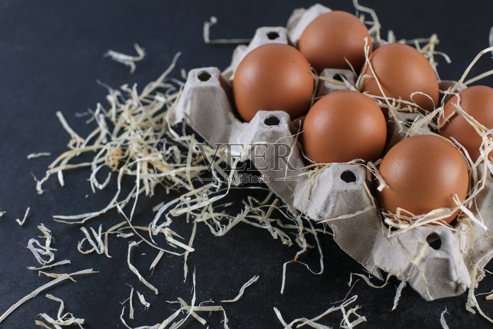 蛋中蛋纸板包装，由回收废纸制成，黑色背景。有机鸡蛋。复活节快乐。照片摄影图片