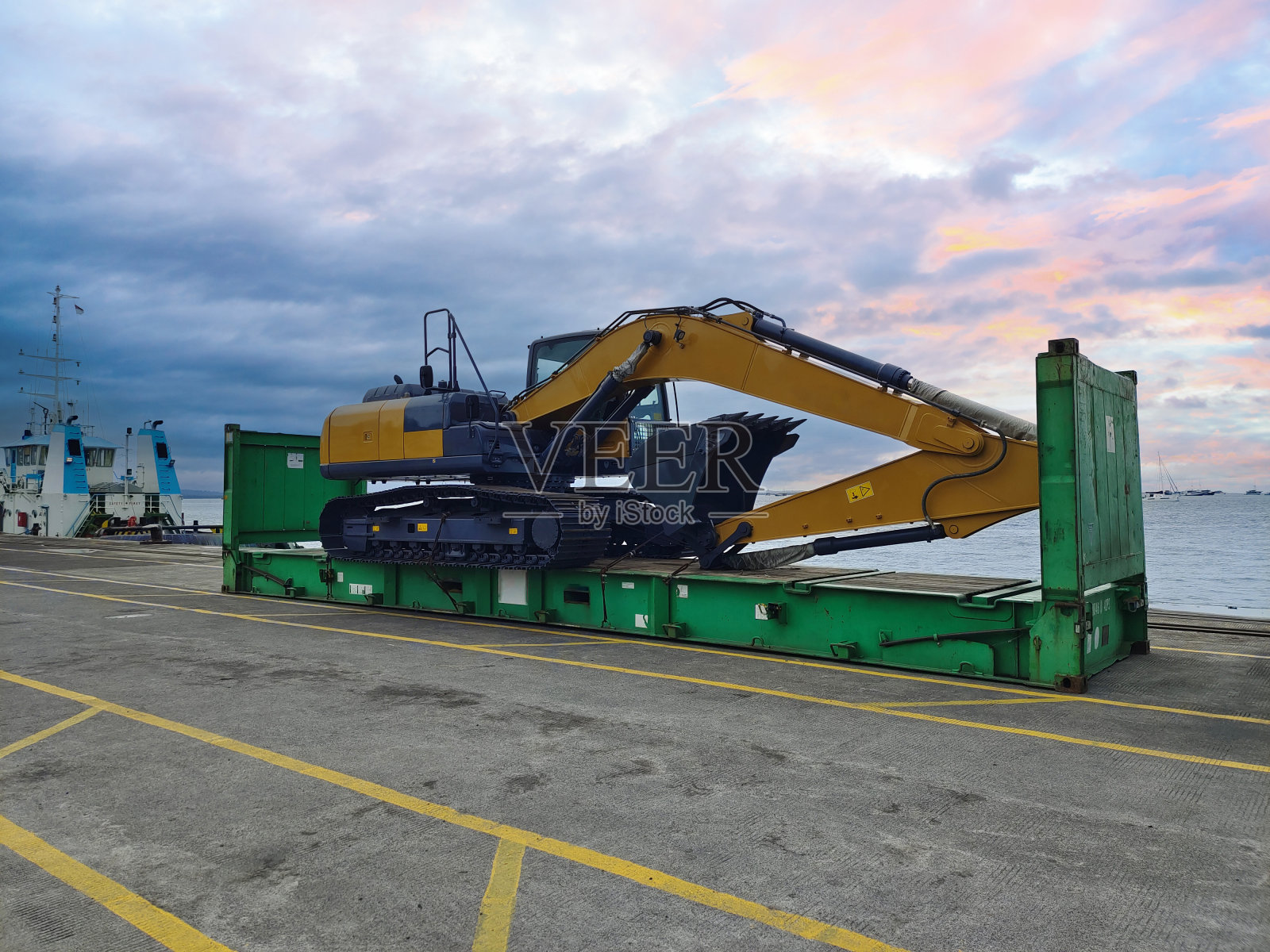 挖掘机在码头卸货。照片摄影图片