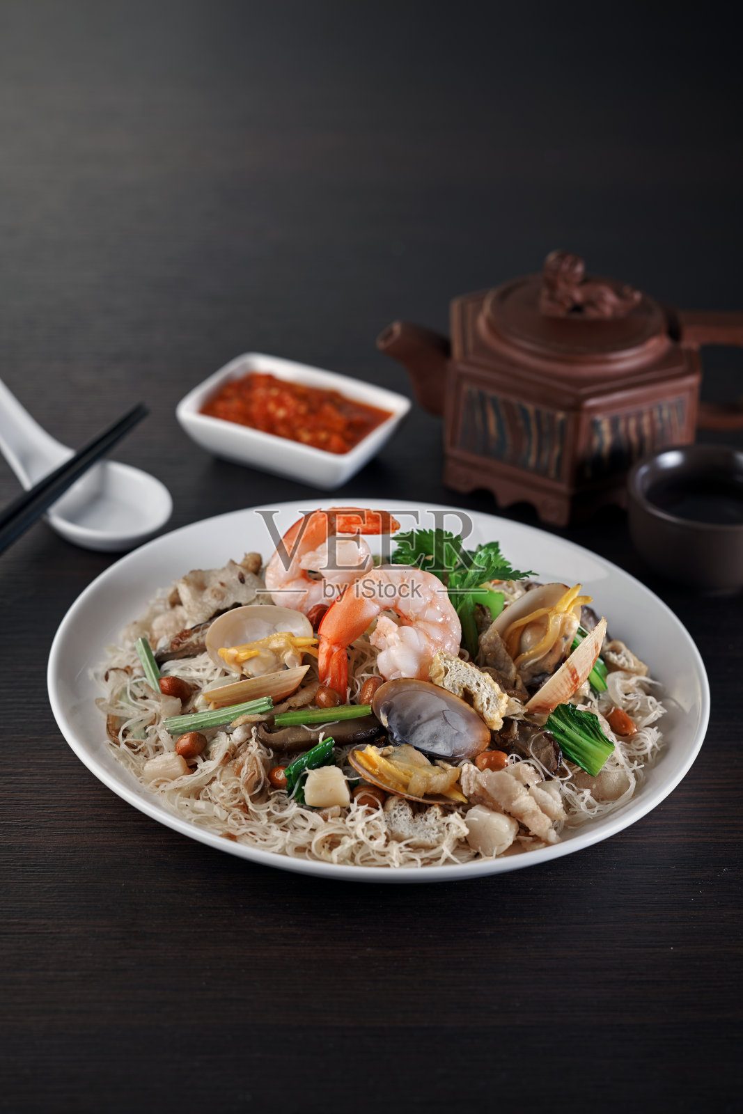 传统的中国健康清炖面条与蛤蜊，虾，海鲜厚汤碗在灰色复古背景咖啡馆酒店豪华清真食品餐厅宴会菜单照片摄影图片