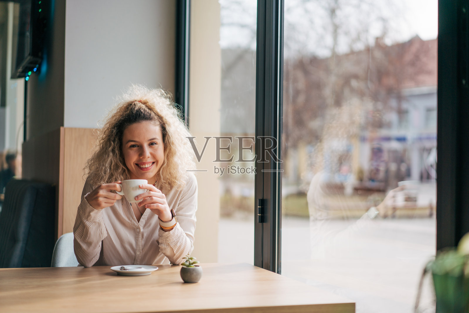 女人一边看书一边喝咖啡照片摄影图片