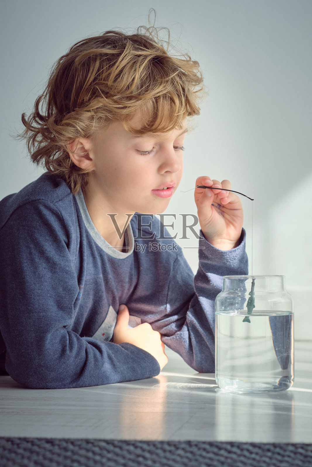 小男孩在玩玩具鱼竿照片摄影图片