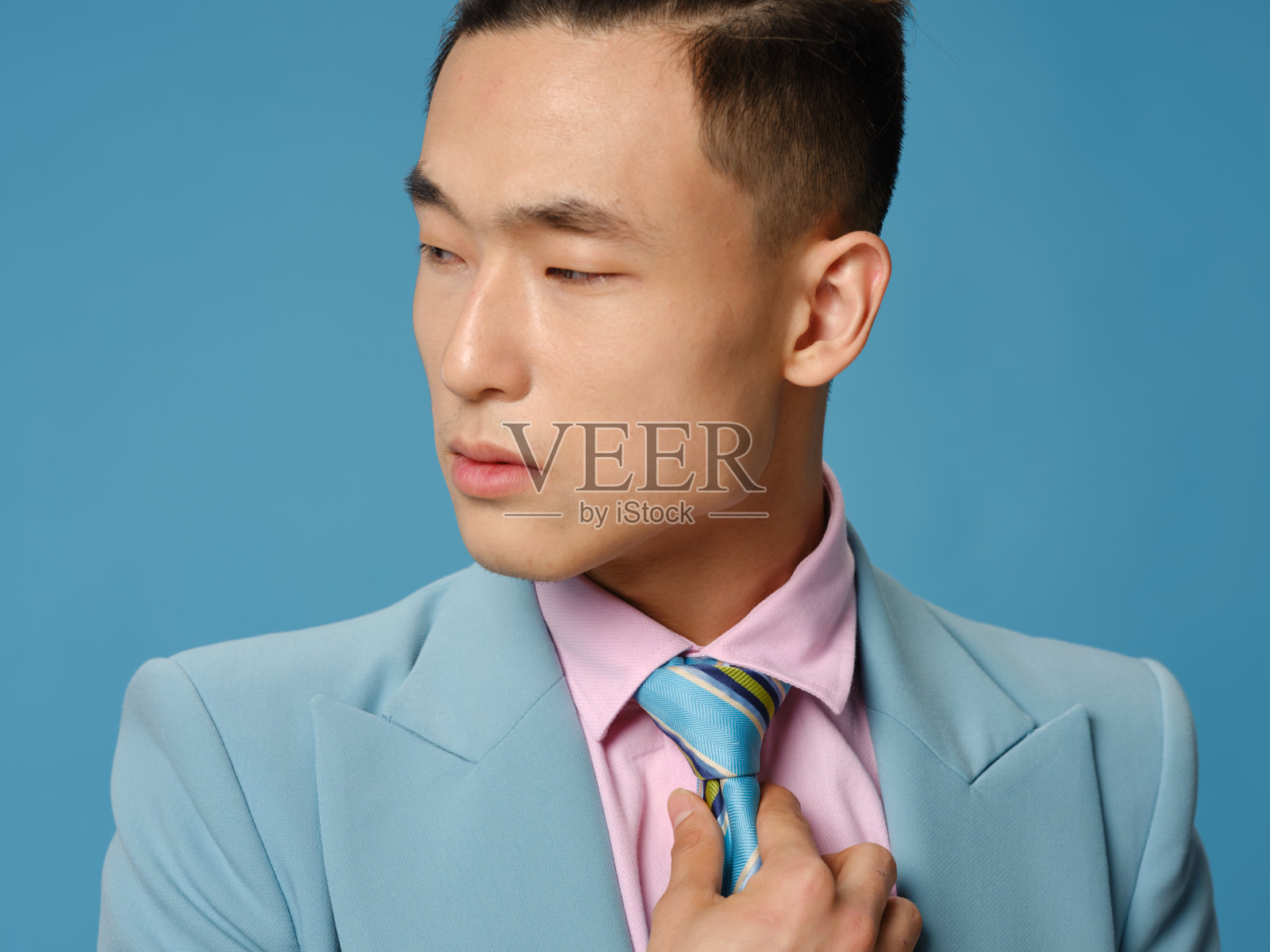 穿着经典西装的时髦商人正着脖子上的领带照片摄影图片