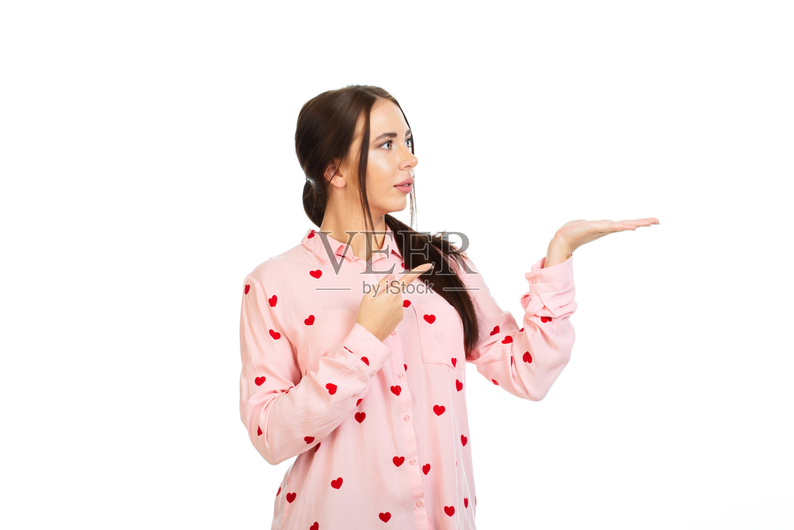 年轻，美丽的女孩孤立在白色的背景中，他的手指指向促销，优惠或广告的地方。照片摄影图片