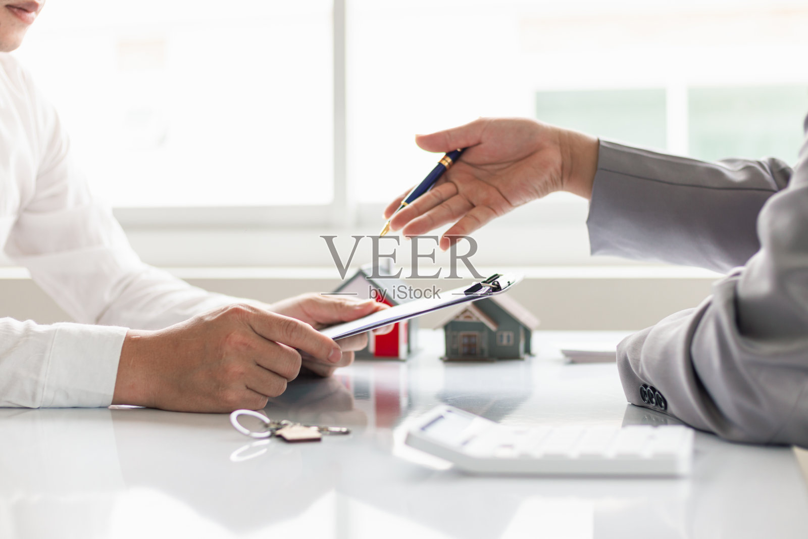 房地产经纪人提供样房供客户选择，并推荐房地产保险促销活动来保护他们的财产。提供房地产和房屋保险的概念照片摄影图片